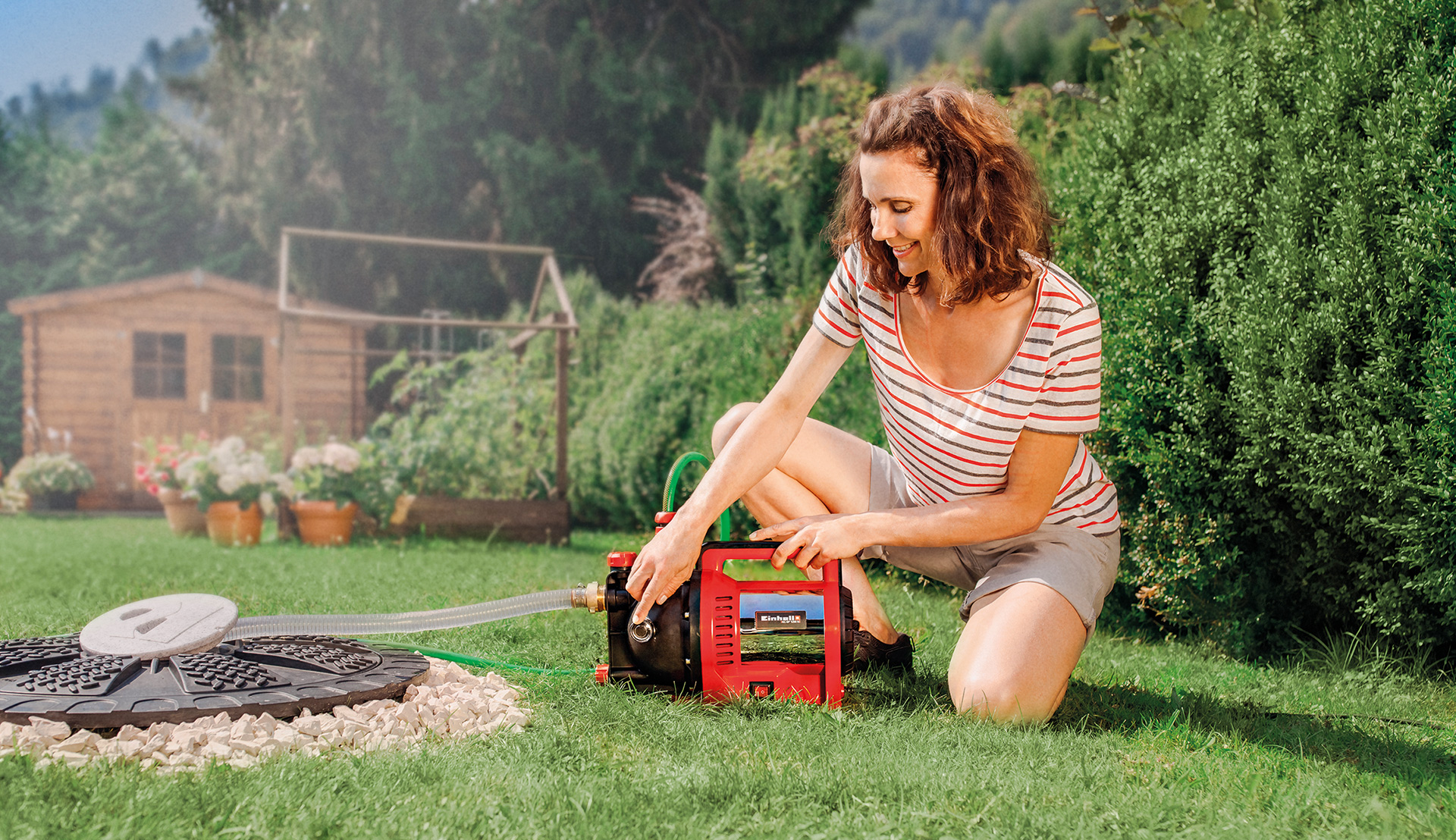 Une femme vérifie l'état de sa pompe de jardin Einhell.