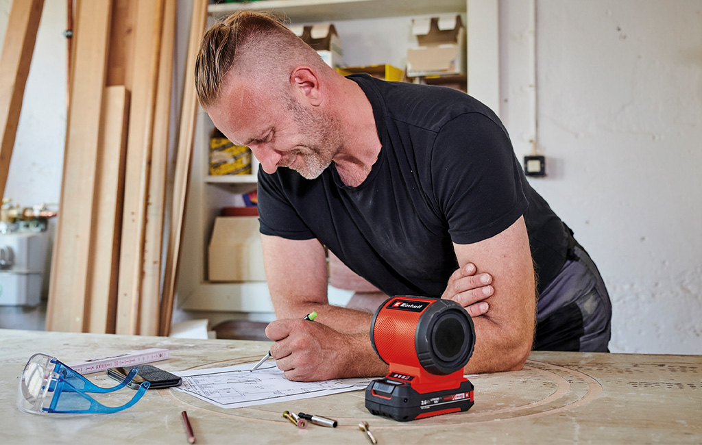 A man is listening to music on the einhell cordless speaker