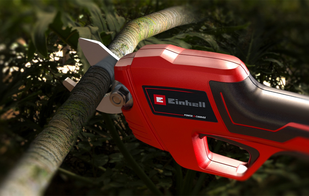 Cordless pruning shears cutting through a branch with sharp bypass blades