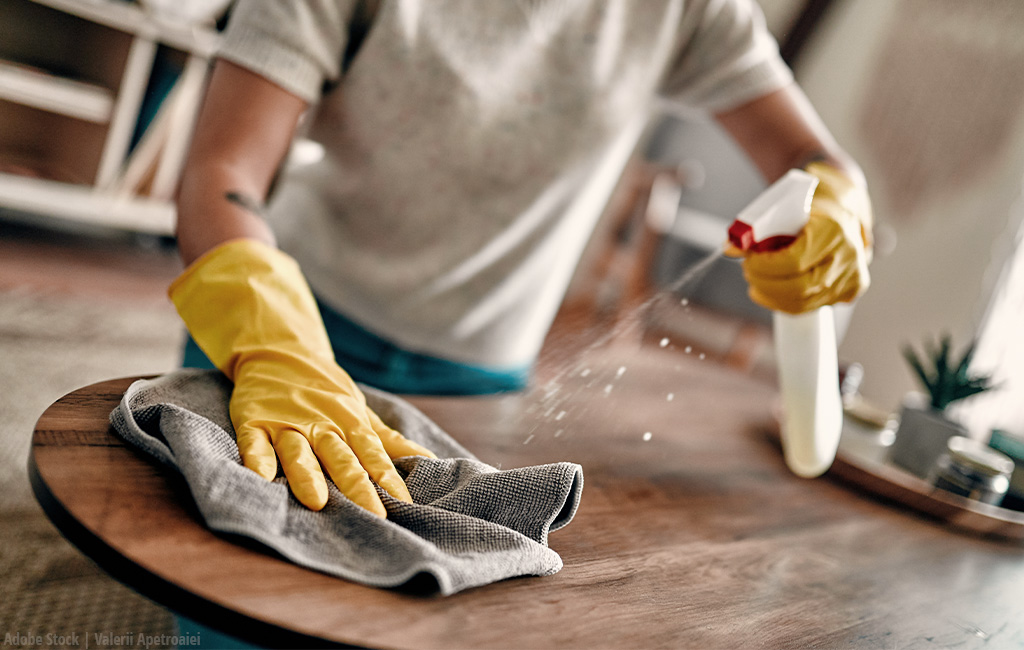 someone is cleaning a tabel with a damp cloth