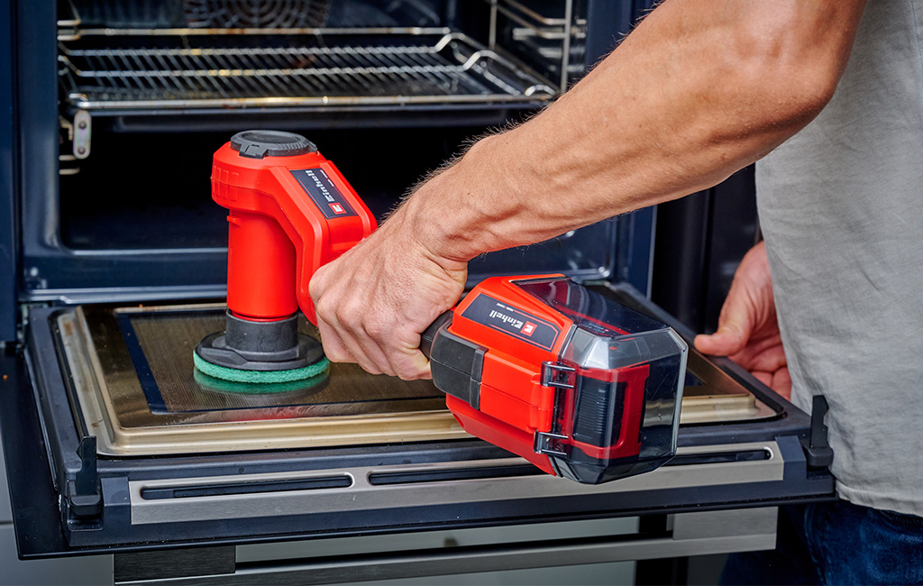 A man cleaning the oven with the cordless surface brush. 