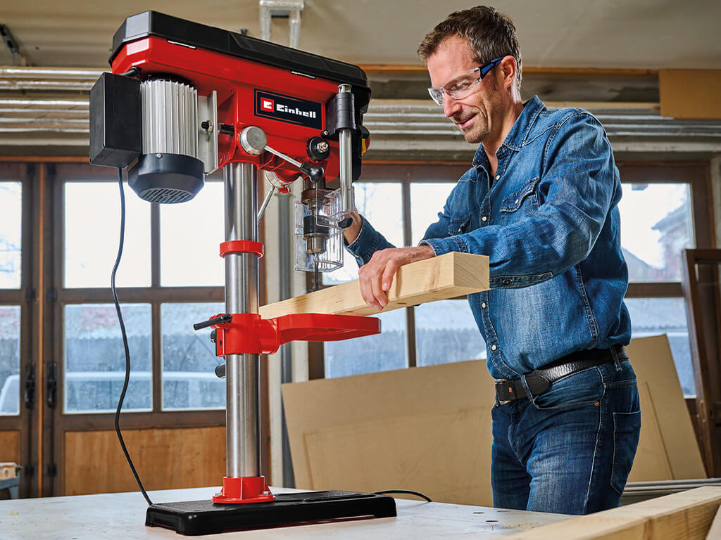 Man drilling into a square timber with an Einhell bench drill.