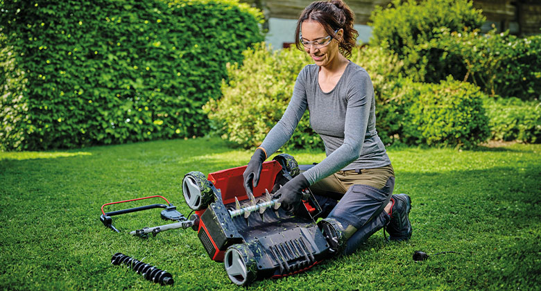 A woman changing the fan roller and blade roller of her scarifier aerator.